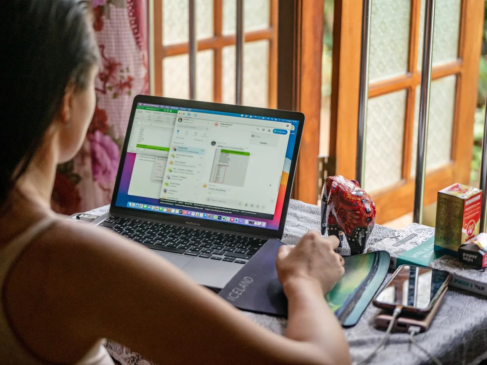Mulher, de costas, a trabalhar numa folha de cálculo no portátil